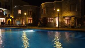 Una piscina al aire libre, sombrillas, tumbonas