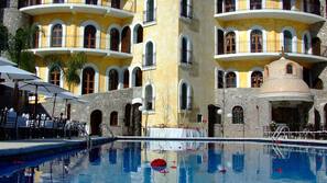 Una piscina al aire libre, sombrillas, tumbonas