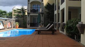 Piscine extérieure, parasols de plage, chaises longues