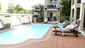 Piscine extérieure, parasols de plage, chaises longues