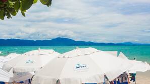 On the beach, white sand, sun-loungers, beach umbrellas