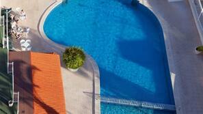 Una piscina al aire libre, una piscina en la azotea, sombrillas