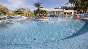 Una piscina cubierta, una piscina al aire libre, sombrillas, tumbonas