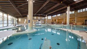 Una piscina cubierta, una piscina al aire libre, sombrillas, tumbonas