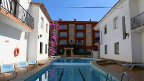 Una piscina al aire libre, tumbonas