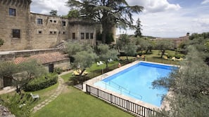 Una piscina al aire libre de temporada, sombrillas