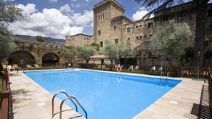 Una piscina al aire libre de temporada, sombrillas