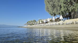 Am Strand, Liegestühle, Sonnenschirme, Wasserski