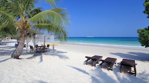 Am Strand, Sonnenschirme, Strandtücher, Kajakfahren