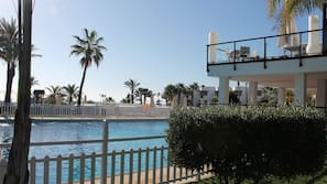 Una piscina al aire libre, sombrillas, tumbonas