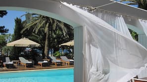 Utomhuspool, parasoller och solstolar