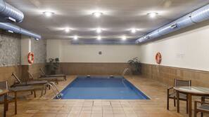 Una piscina cubierta, una piscina al aire libre, sombrillas, tumbonas