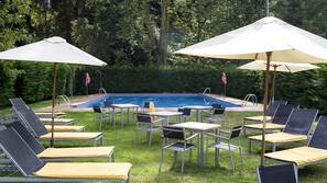 Una piscina cubierta, una piscina al aire libre, sombrillas, tumbonas
