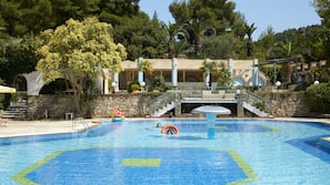 Una piscina al aire libre, sombrillas, tumbonas