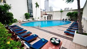 Una piscina al aire libre, sombrillas