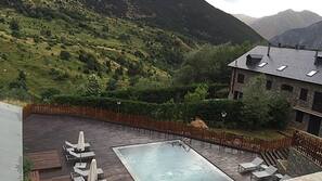 Una piscina al aire libre de temporada, sombrillas, tumbonas