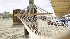 Een privéstrand, cabana's (toeslag), ligstoelen aan het strand, parasols