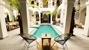 Una piscina al aire libre, sombrillas, tumbonas
