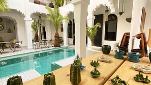 Una piscina al aire libre, sombrillas, tumbonas
