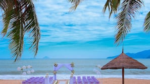 On the beach, white sand, sun-loungers, beach umbrellas
