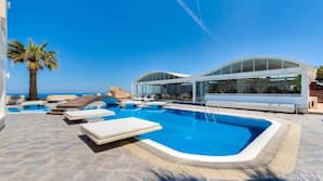 Piscine extérieure, parasols de plage, chaises longues
