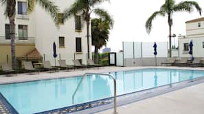 Una piscina al aire libre, tumbonas