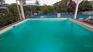 Una piscina cubierta, una piscina al aire libre, tumbonas