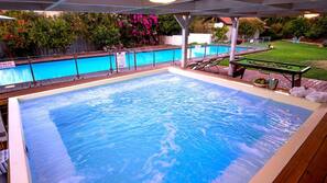 Una piscina cubierta, una piscina al aire libre, tumbonas
