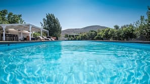 Una piscina cubierta, una piscina al aire libre, tumbonas