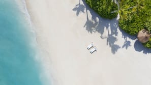 Plage privée, sable blanc, cabines (en supplément), chaises longues