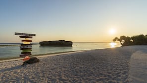 On the beach, white sand, sun-loungers, beach umbrellas