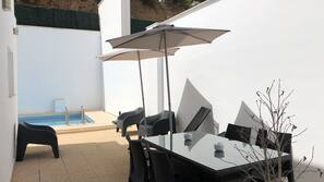 Una piscina al aire libre, sombrillas, tumbonas
