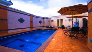 Outdoor pool, open 10:00 AM to 7:00 PM, pool umbrellas