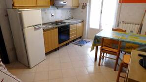 Full-size fridge, stovetop, cookware/dishes/utensils