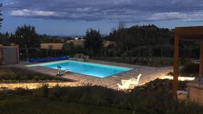 Una piscina al aire libre de temporada, sombrillas, tumbonas