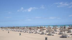 Aan het strand, ligstoelen aan het strand, parasols, strandlakens