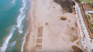 Aan het strand, ligstoelen aan het strand, parasols, strandlakens