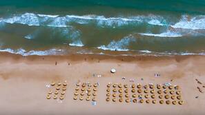 Aan het strand, ligstoelen aan het strand, parasols, strandlakens