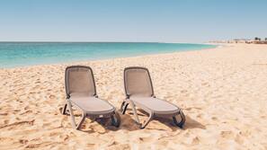 Privéstrand vlakbij, wit zand, ligstoelen aan het strand, parasols
