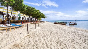 On the beach, white sand, sun loungers, beach towels
