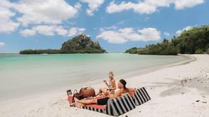 On the beach, white sand, sun-loungers, beach towels
