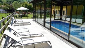 Una piscina cubierta, una piscina al aire libre de temporada
