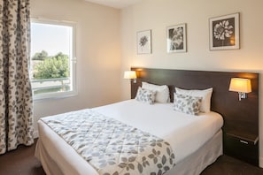 Premium bedding, laptop workspace, blackout drapes, soundproofing