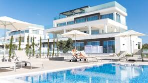 Piscine extérieure, parasols de plage, chaises longues