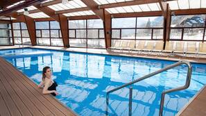 Una piscina cubierta, tumbonas