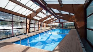 Una piscina cubierta, tumbonas