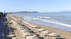 Sulla spiaggia, lettini da mare, ombrelloni, windsurf