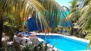 Una piscina al aire libre, tumbonas