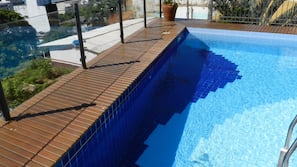 Piscine extérieure, parasols de plage, chaises longues