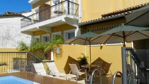 Piscine extérieure, parasols de plage, chaises longues